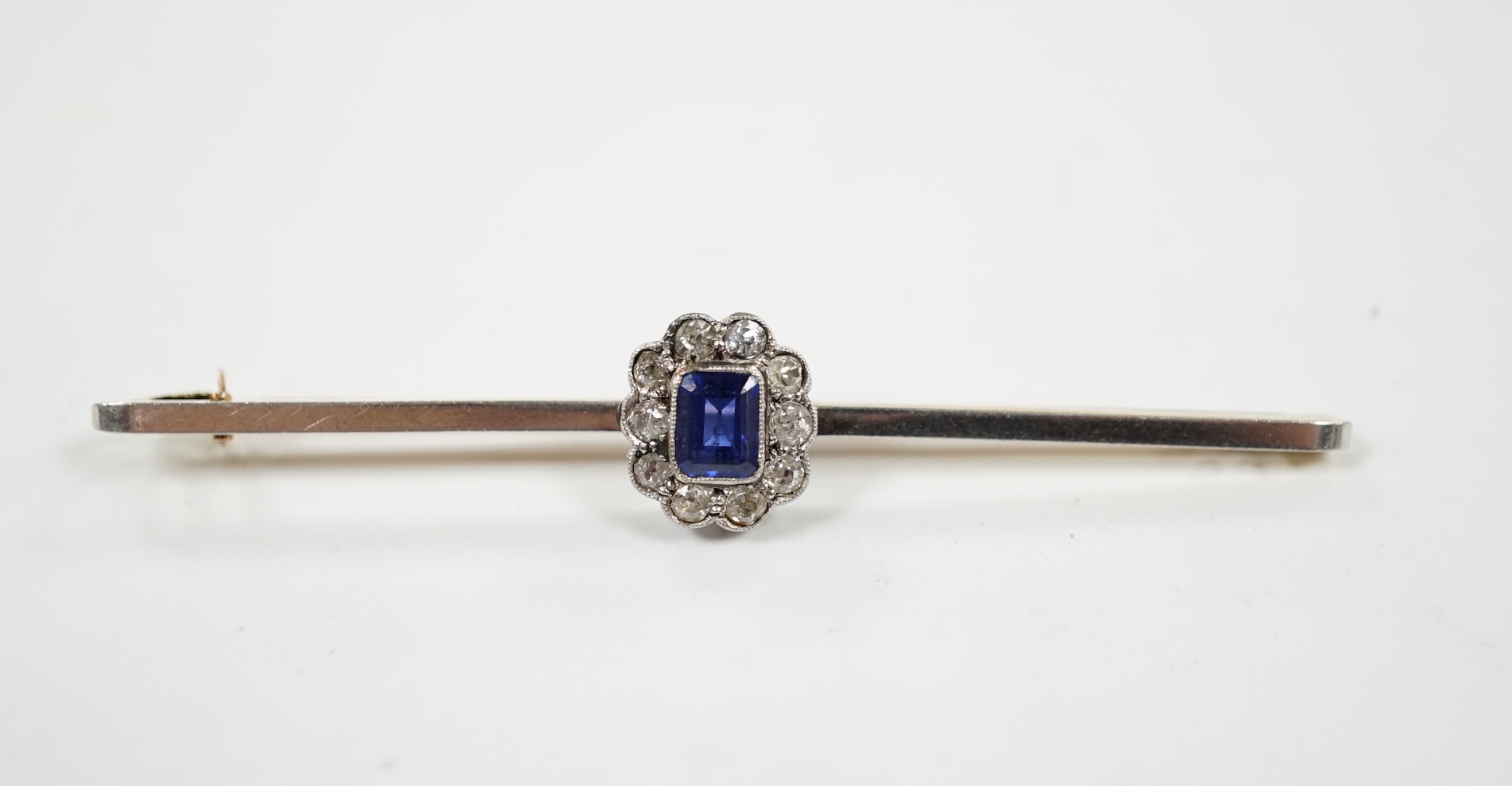 An early 20th century 15ct and plat, sapphire and diamond oval cluster set bar brooch, 64mm, gross weight 4.1 grams.